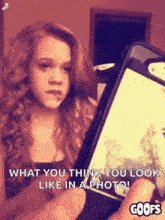 a young girl is taking a picture of herself with her cell phone .