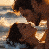 a man and a woman are kissing on the beach with their eyes closed
