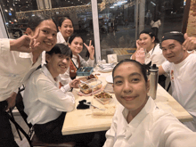 a group of people sitting at a table with a man wearing a hat that says nike on it