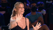 a woman in a black lace top is smiling in front of a sign that says talent
