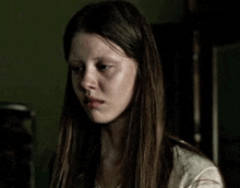 a woman with long brown hair is looking at the camera