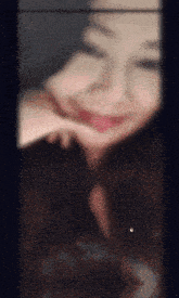 a blurry photo of a woman with her hand on her face