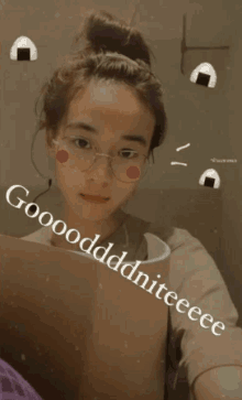 a girl with glasses and a bun says gooodddddniteeeee