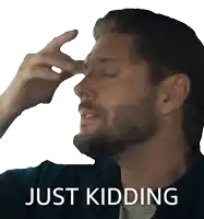 a man with his hand on his forehead and the word just kidding below him