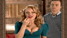 a woman is applying red lipstick in front of a man