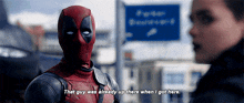 deadpool is talking to a woman in front of a sign that says police station