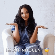 a woman is sitting in a chair with her hands outstretched and the words `` im an innocent '' above her .