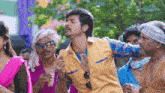 a man in a yellow shirt is surrounded by other people