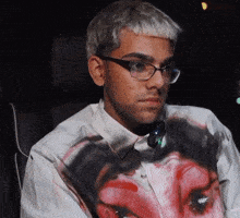 a man wearing glasses and a shirt with a painting of a woman on it