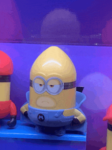 a yellow and blue minion with a m on his chest