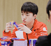 a boy wearing a red jacket that says kimsung