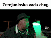 a man in a top hat is drinking from a green cup