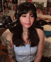 a woman wearing headphones and a tank top is sitting in front of a microphone in a room .