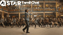 a group of people are dancing in front of a star tamil chat logo