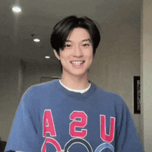 a young man is wearing a blue shirt with the letters a2u on it .
