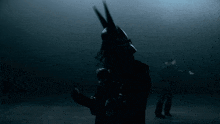 a person in a dark room with a mask on