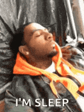 a man is sleeping on a bed with the words `` i 'm sleep '' written next to him .