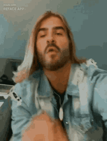 a man with long blonde hair and a beard is making a funny face