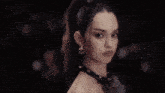 a woman is holding a large knife in her hand in a crowd of people .