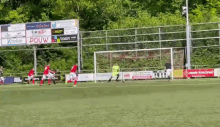 a soccer game is being played on a field with a boon sign behind the goal