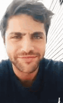 a close up of a man 's face with a beard making a face .
