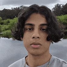 a young man with long curly hair is looking at the camera