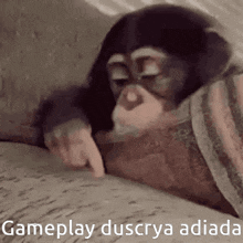 a chimpanzee is laying on a couch and pointing at a book .