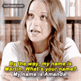 a woman is sitting in front of a bookshelf and talking to another woman .