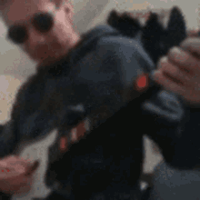 a blurry photo of a man wearing sunglasses and a hoodie