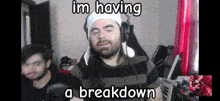 a man wearing headphones and a white hat is having a breakdown
