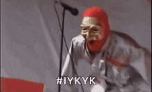 a man wearing a red mask is making a funny face and screaming .