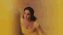 a woman in a yellow dress with a gold necklace
