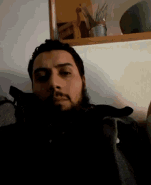 a man with a beard is laying on a couch