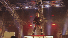 a man is playing a guitar on a stage with the number 28 on his pants