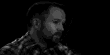 a black and white photo of a man with a beard .