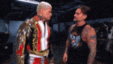 two wrestlers are standing next to each other and one has a black tank top with a eagle on it