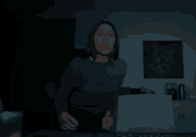 a woman is standing in a dark room with a picture on the wall that says ' i 'm sorry '