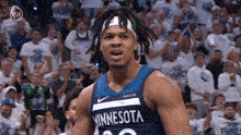 a man in a minnesota jersey stands in front of a crowd of people