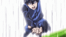 a boy in a blue shirt is kneeling down in the rain with his mouth open .