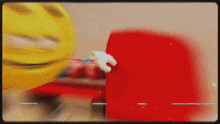 a yellow smiley face is standing next to a red item