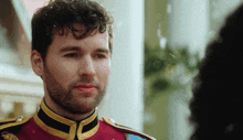 a man with a beard wearing a red and yellow uniform