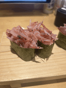 a close up of a sushi filled with shrimp on a wooden table