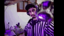 a man wearing headphones and a referee 's uniform is holding a purple object .