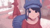 a girl wearing a blue hat and a red shirt is laying on her stomach