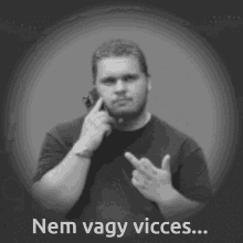 a black and white photo of a man talking on a cell phone with the words nem vagy vicces below him