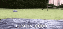 a person is laying on a blanket in the grass with the words `` cum on innnn '' written on the bottom .