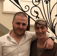 two men posing for a picture with one wearing a leopard print bandana