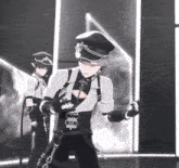 a man in a black and white outfit is dancing with a sword