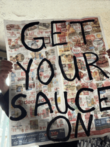 a person is holding a newspaper that says " get your sauce on "