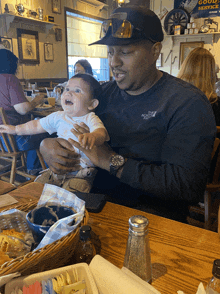 a man holding a baby wearing a north face shirt